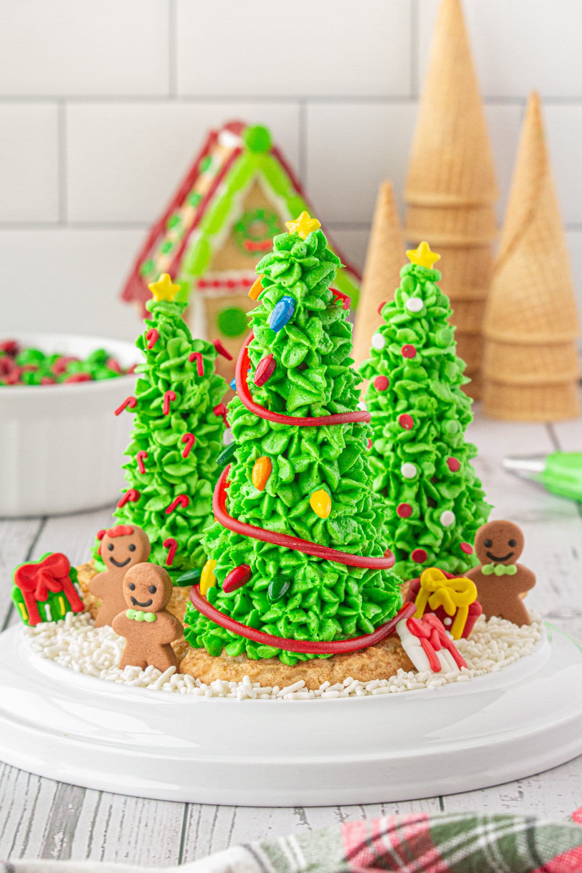 Three finished Christmas tree cones on a cake plate.