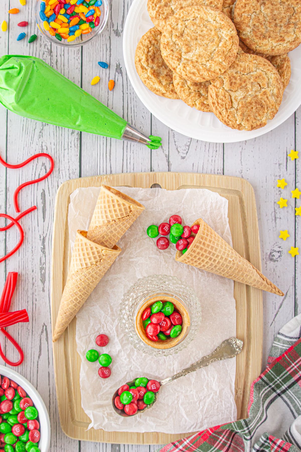 Sugar cones being filled with red and green m&ms candy.