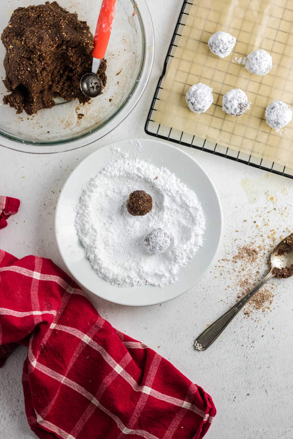 Bourbon balls being rolled in powdered sugar.