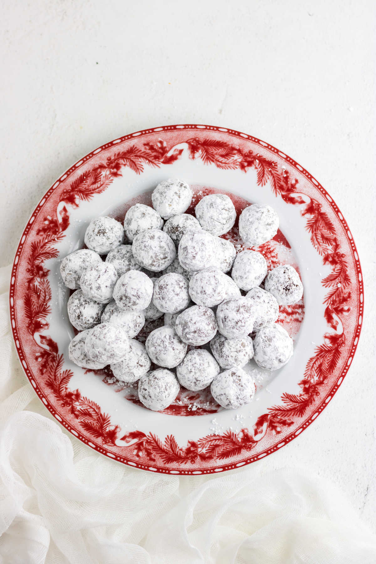Overhead view of bourbon balls on a red christmas plate.