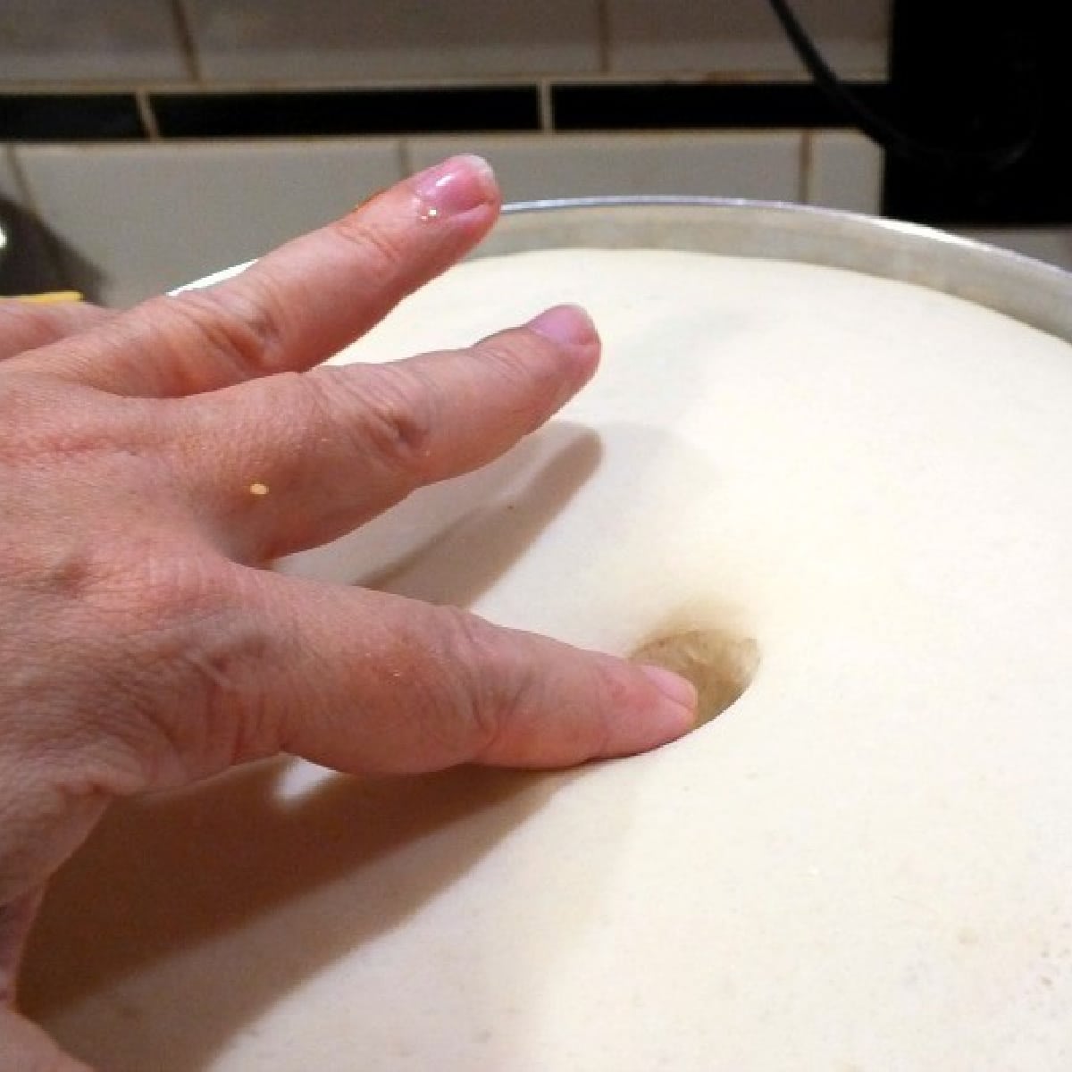 Pushing a finger in bread dough to check if it's risen.