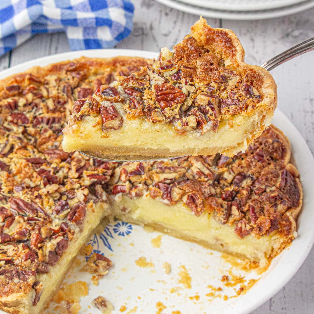 Closeup of a slice of creamy buttermilk pecan pie being served.