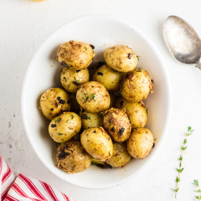 Roasted baby potatoes in a white bowl.