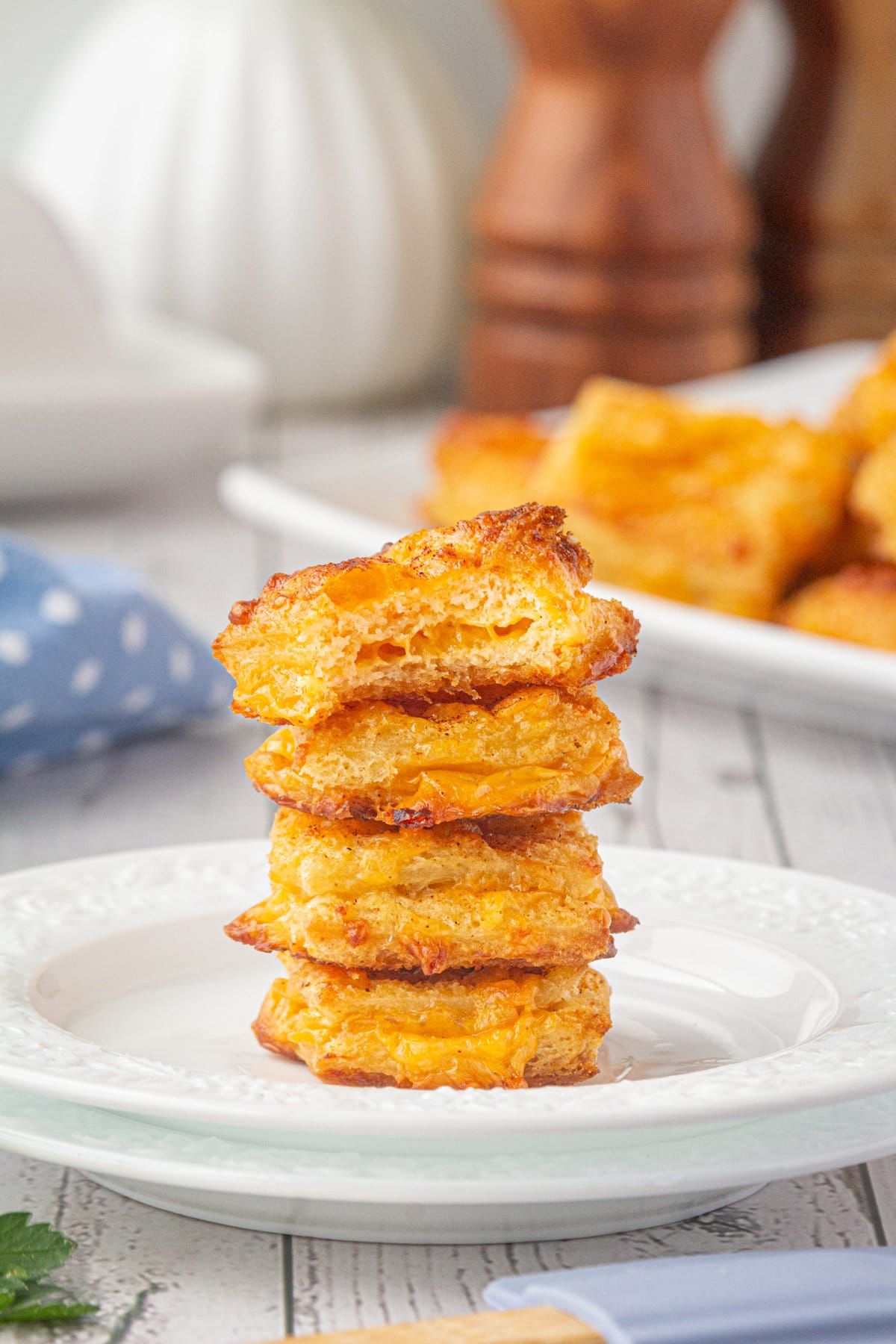 A stack of cheese dreams on a white plate.