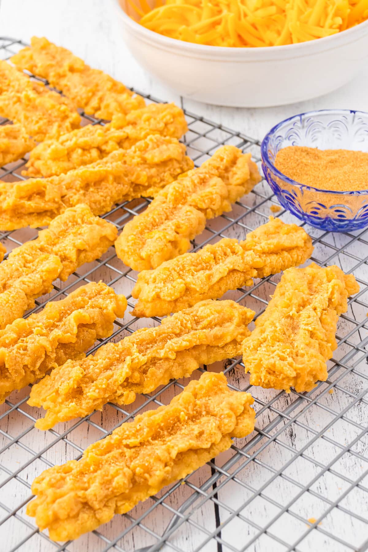 An up-close photo of cheese straws on a cooling rack.