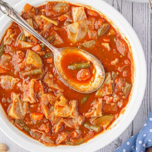 Overhead view of vegetable soup with a spoon in it.