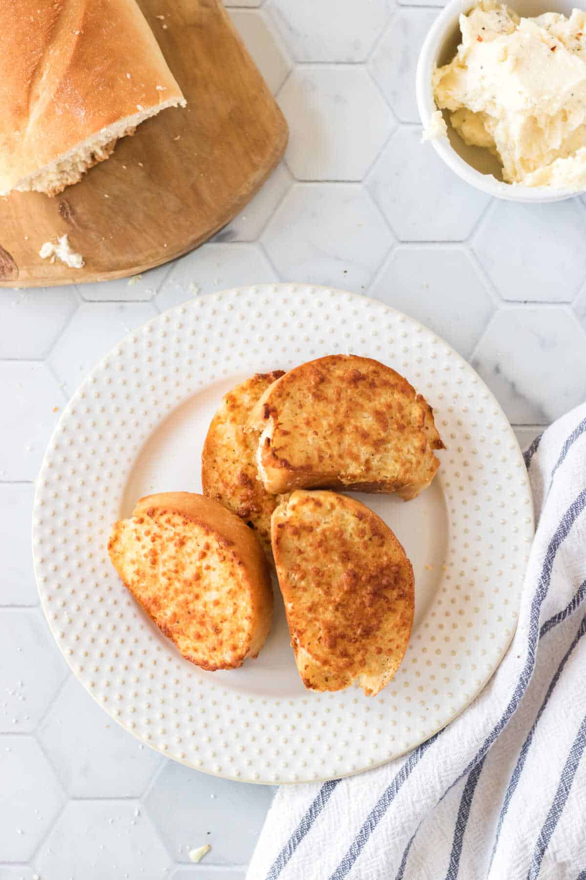 Overhead view of a plate of crunchy garlic bread.