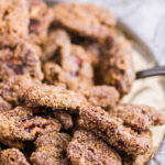 Closeup of pecans in a candy dish with a title text overaly.