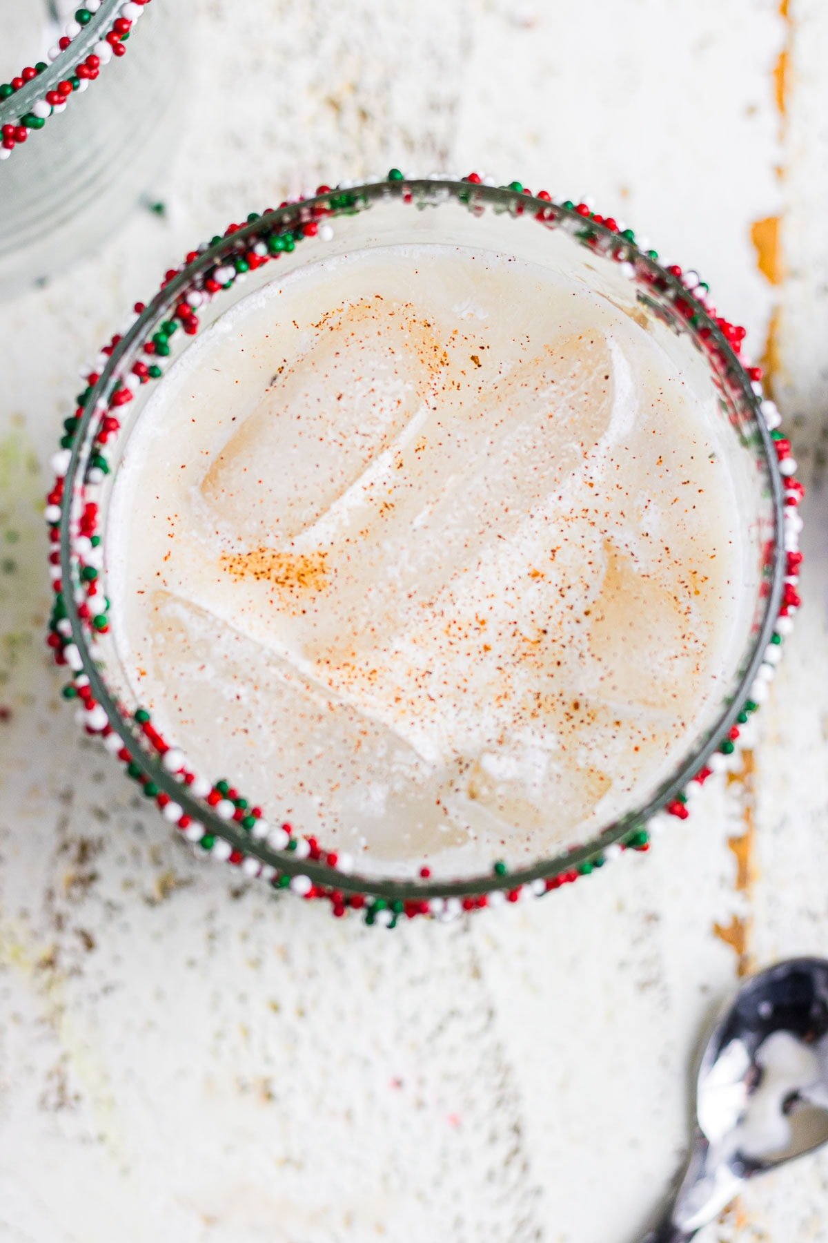 An overhead view of the white Russian Christmas cookie cocktail in a sprinkle-rimmed glass.