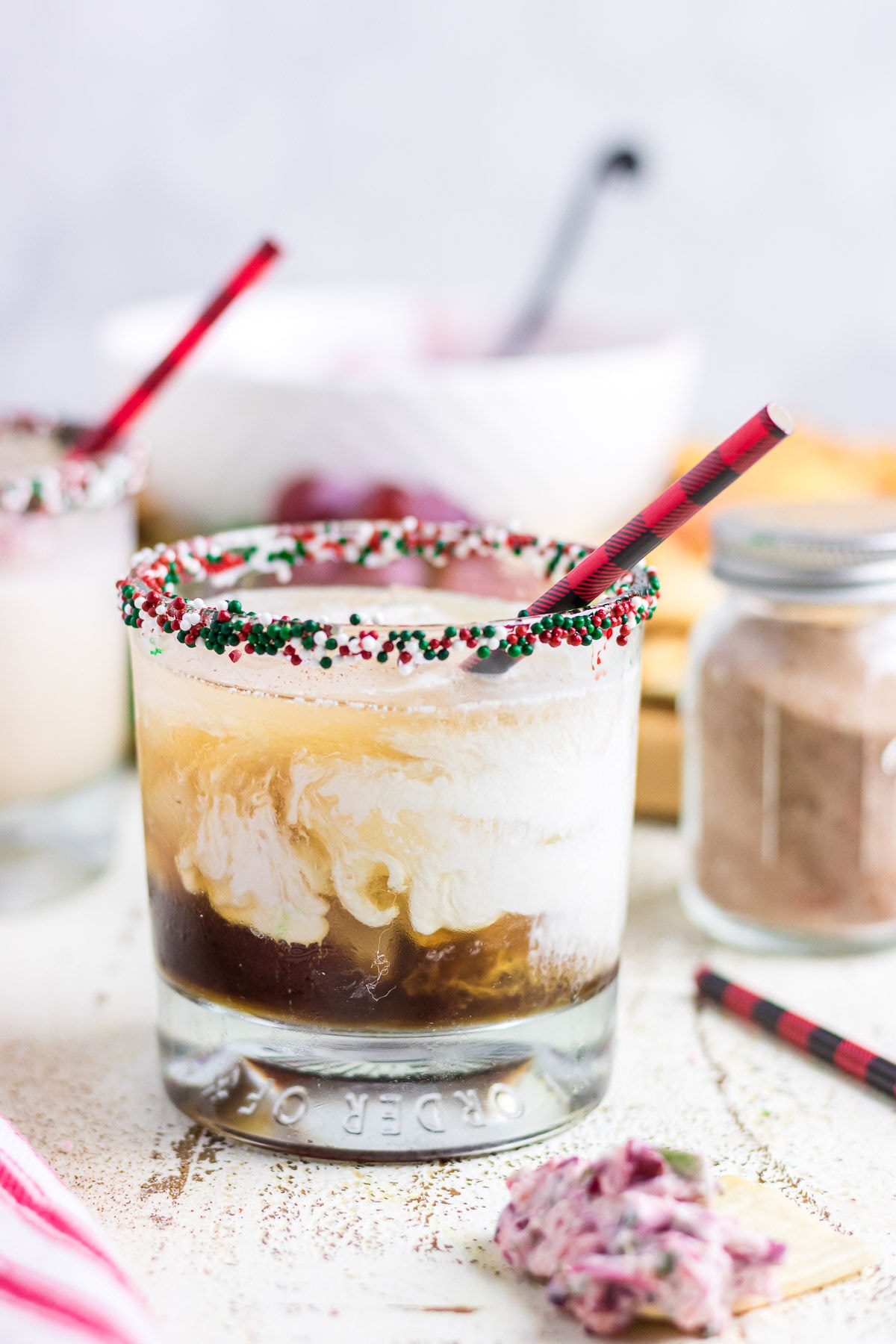 A Christmas cocktail in a small glass with a sprinkled rim.