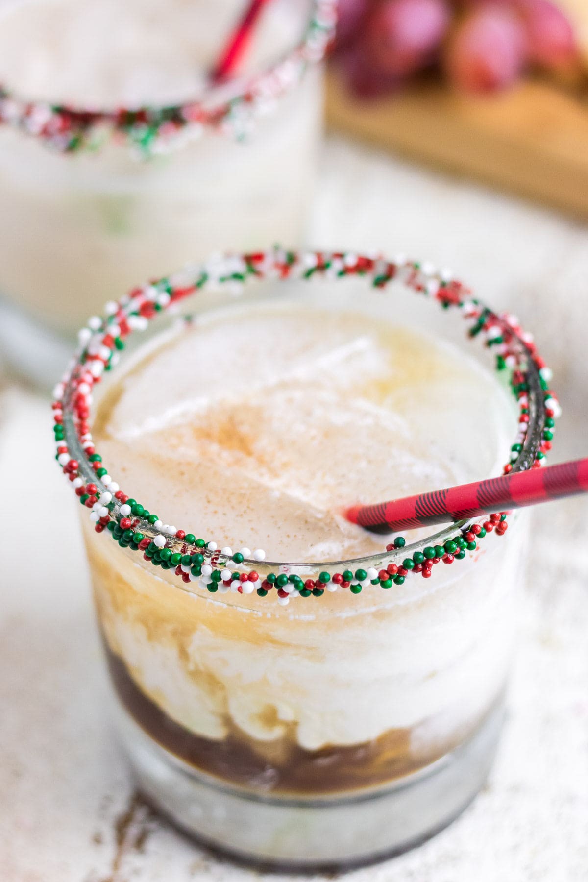 An up-close view of the White Russian Christmas cookie cocktail in a sprinkle-rimmed low ball glass.