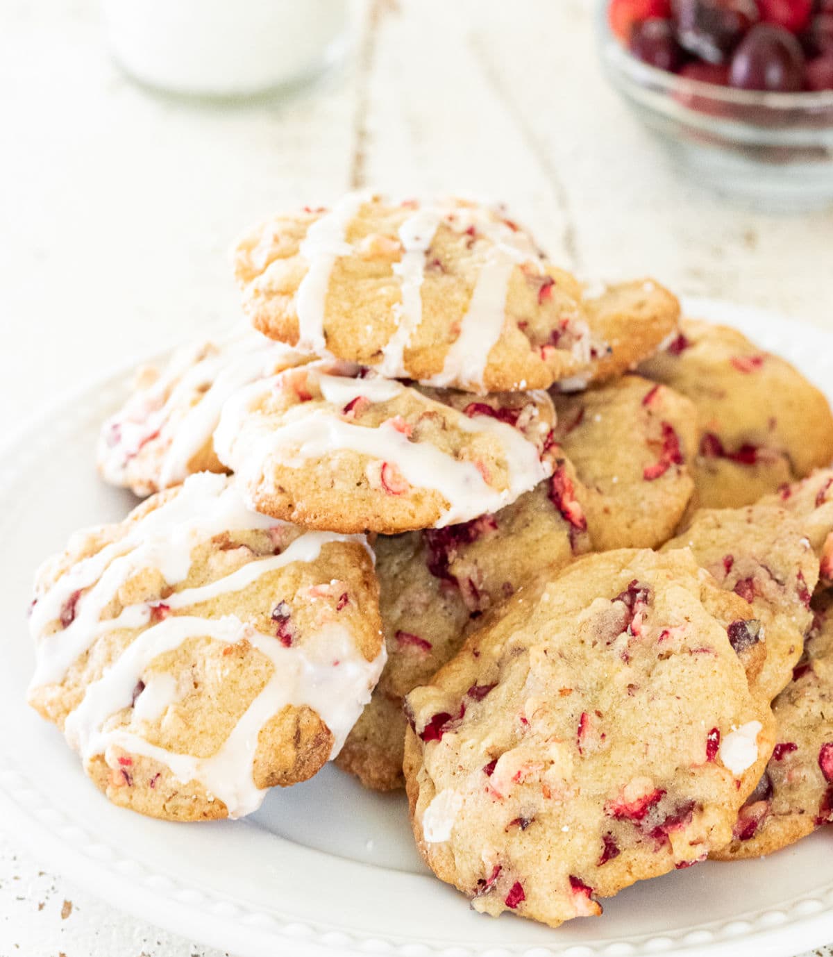 A pile of cranberry cookies on a white plate.
