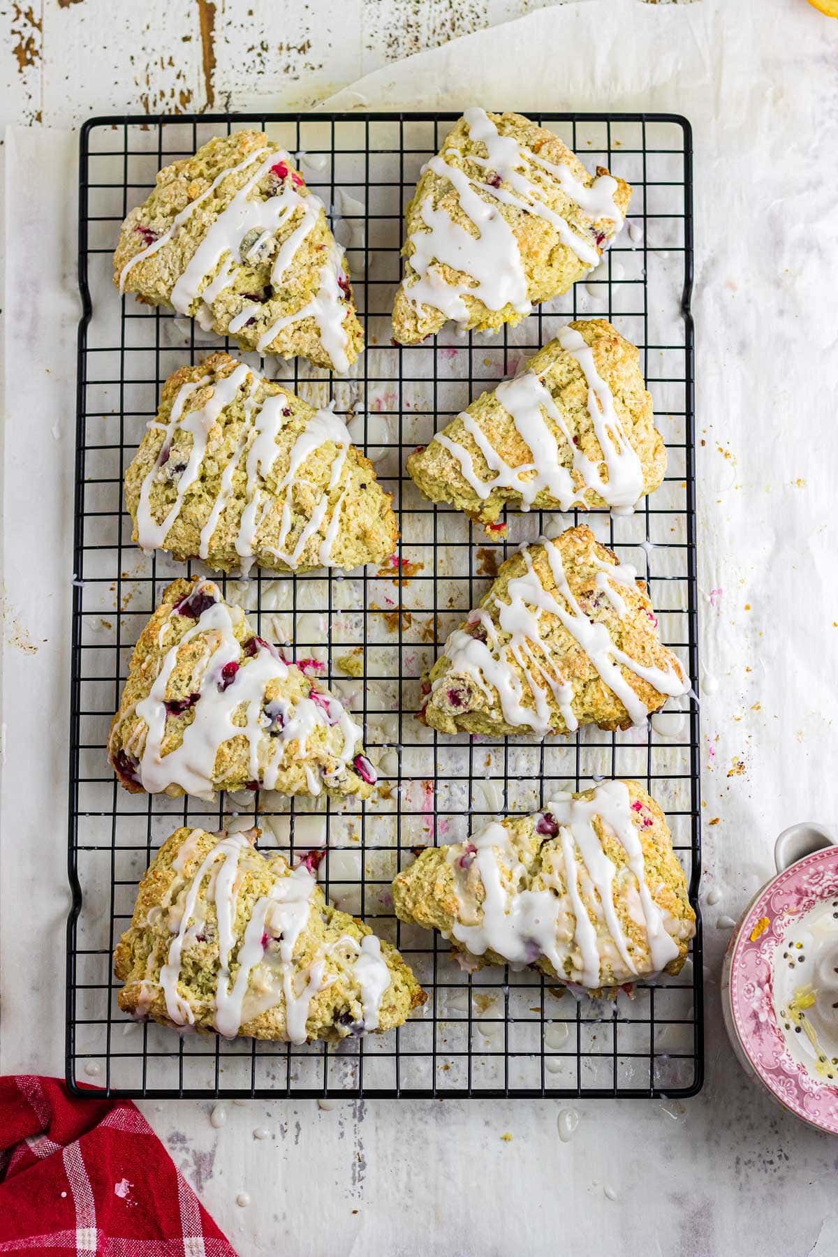 An overhead image of glazed cranberry scones on a wire cooling rack.
