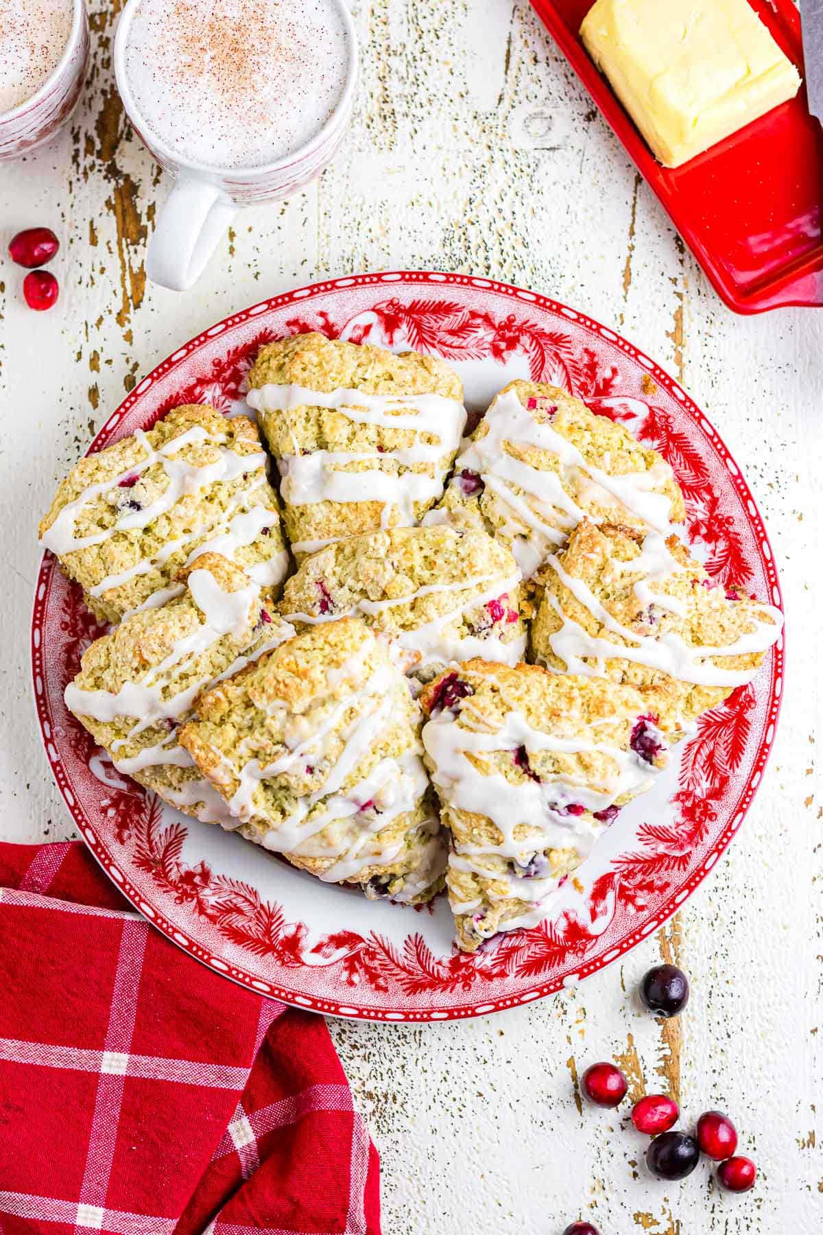 An overhead photo of glazed cranberry scones on a red plate.