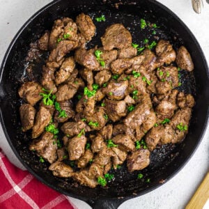 Overhead view of a cast iron skillet with garlic steak bites in it.