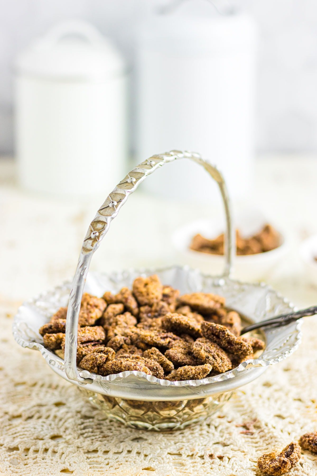 An up-close photos of spiced candied pecans in a decorative bowl.