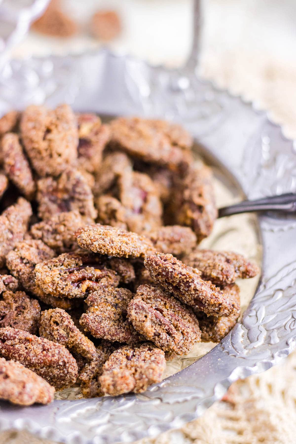 An up-close photo of candied pecans in a glass bowl.