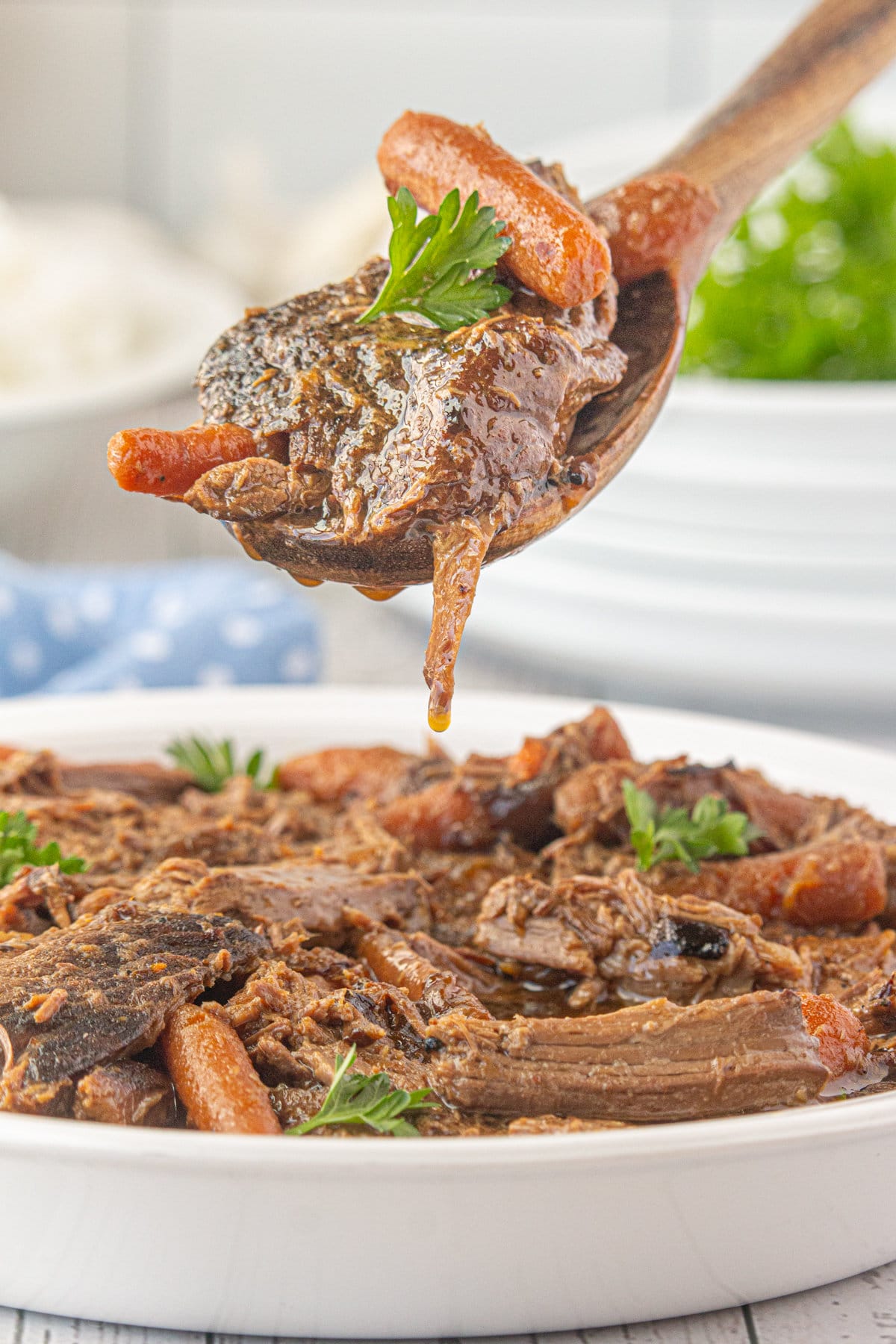 Rump roast and carrots in a shallow serving bowl.