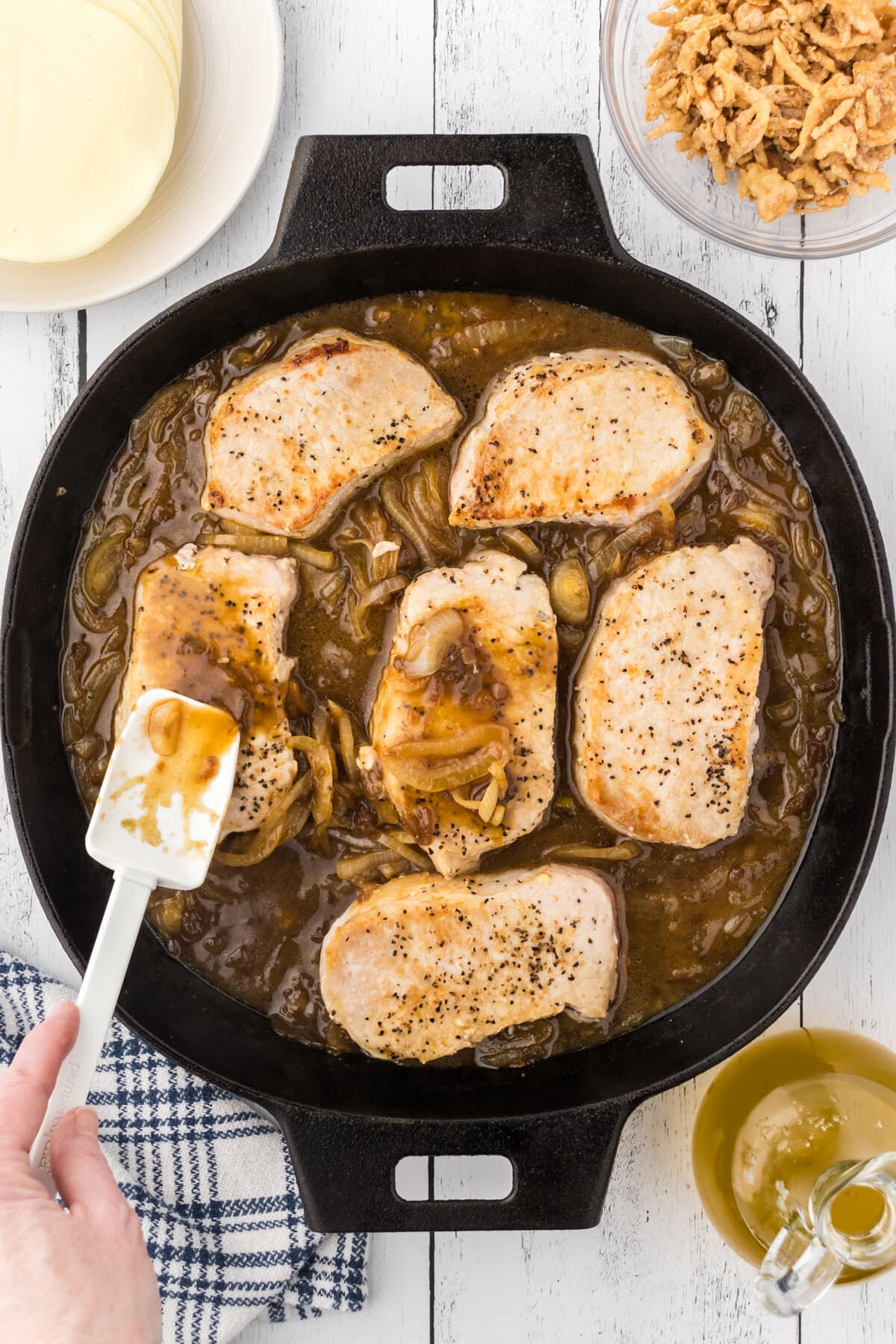 Simmering the browned pork chops in the French onion soup.