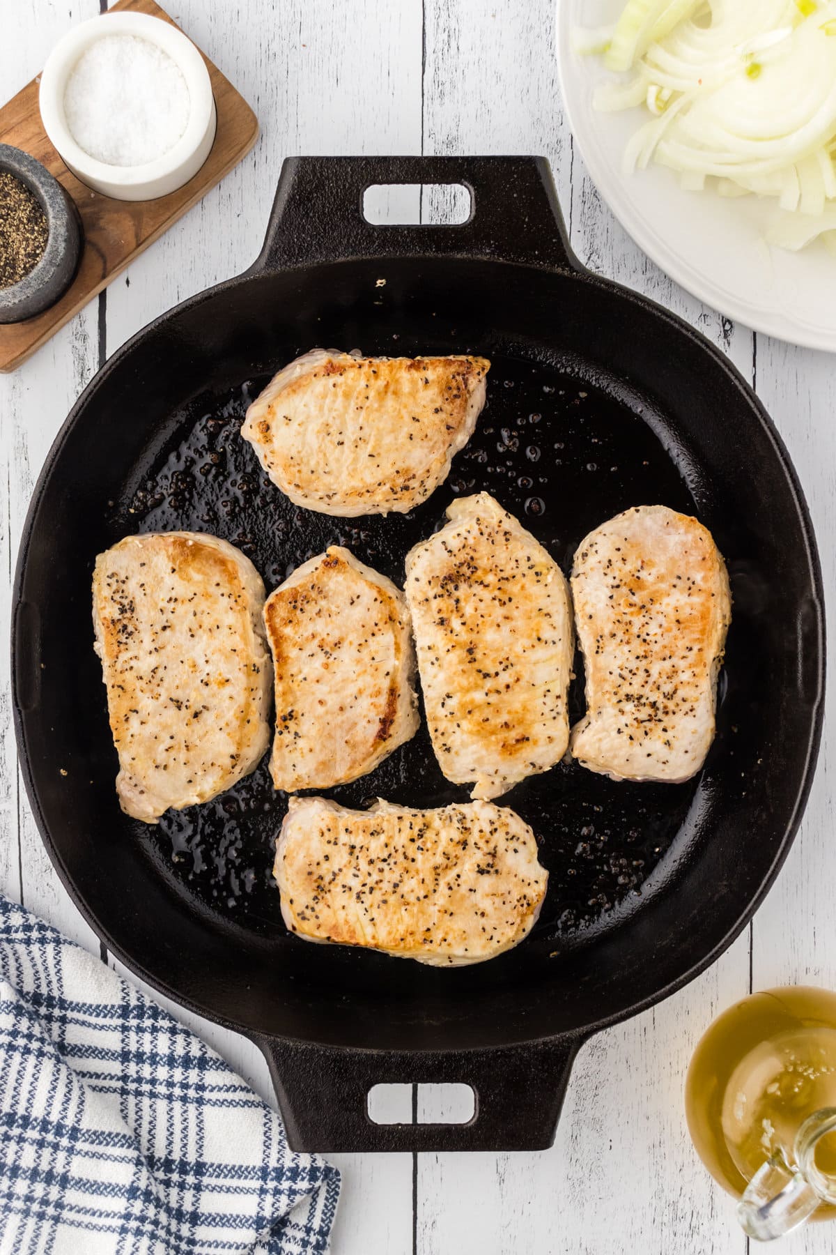 Pork chops browning in the skillet.