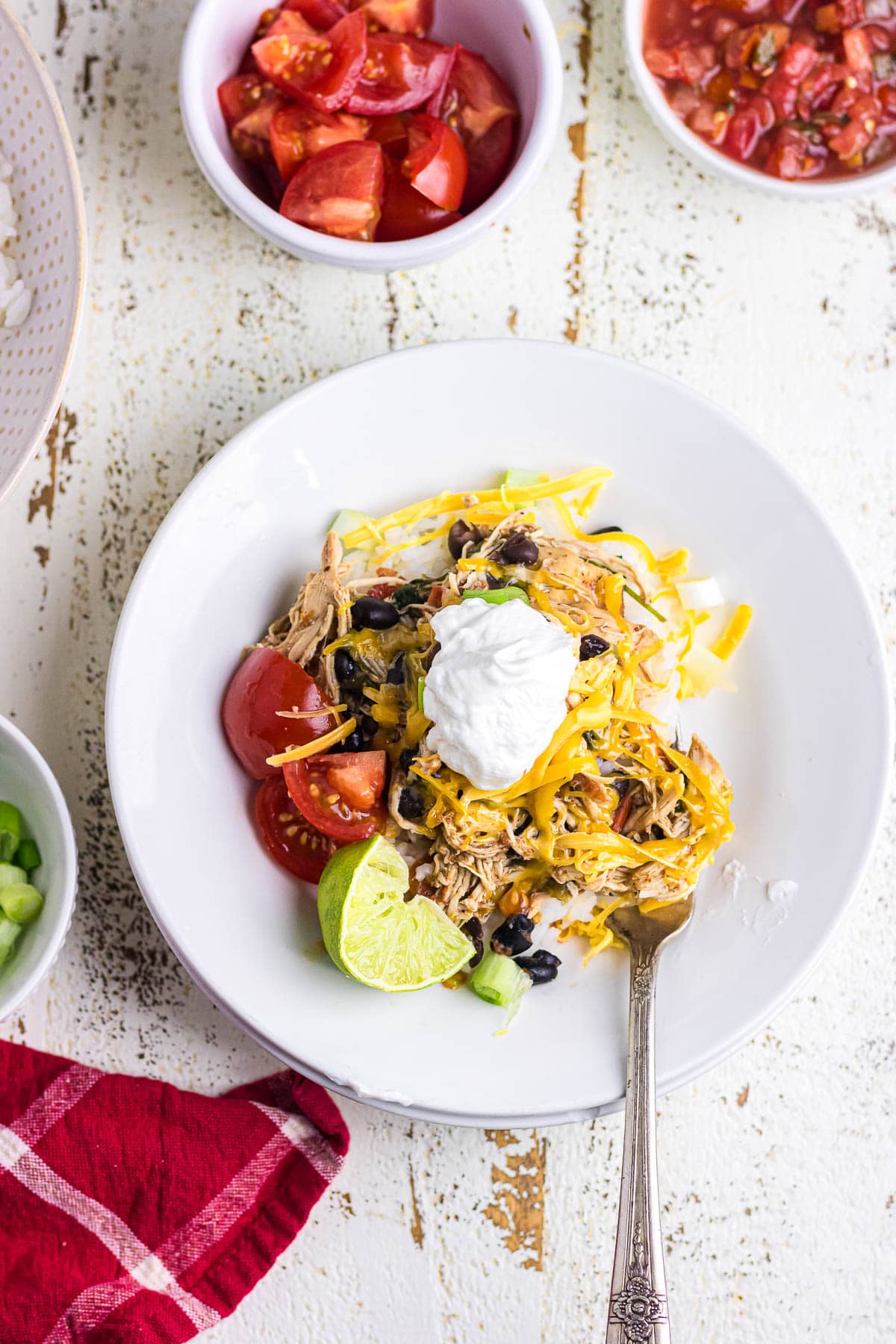 A chicken burrito bowl topped with cheese and sour cream.