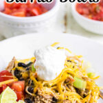 Closeup of a chicken burrito bowl with layers of rice, juicy southwestern seasoning chicken, and cheese. Title text overlay for Pinterest.
