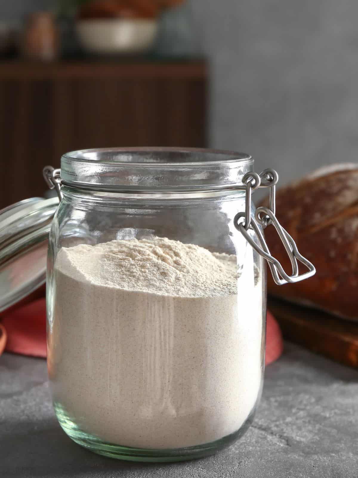 A jar of homemade dough enhancer on a counter.