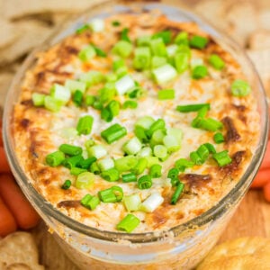 Closeup view of baked Mississippi Sin Dip with green onions on top.