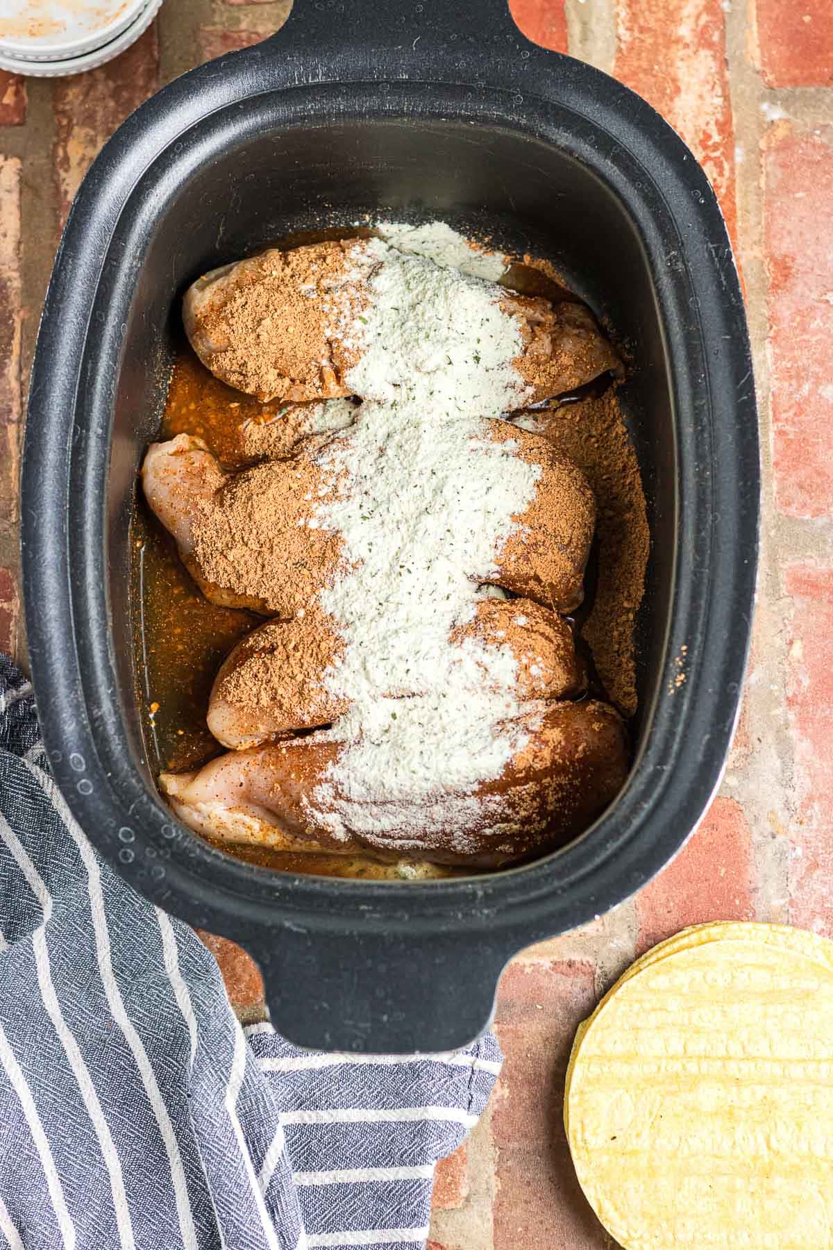 Chicken breasts in crockpot with ranch and taco seasoning.
