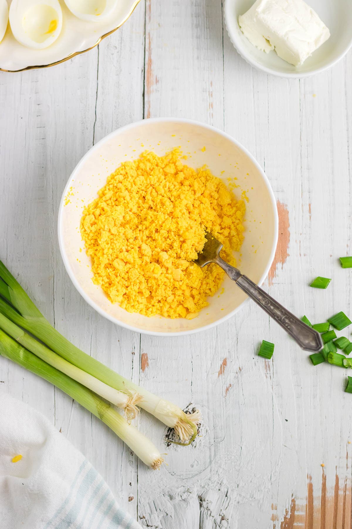 Egg yolks crumbled in a mixing bowl.