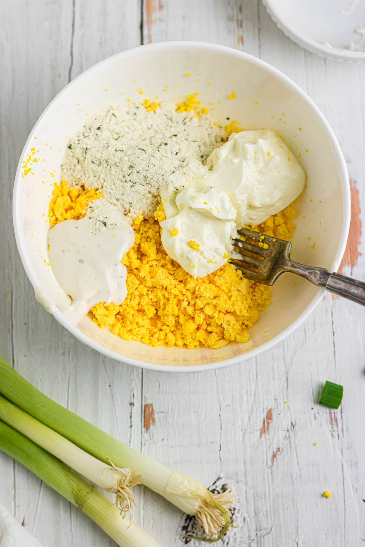 Hard boiled egg yolks with remaining ingredients for deviled egg filling.