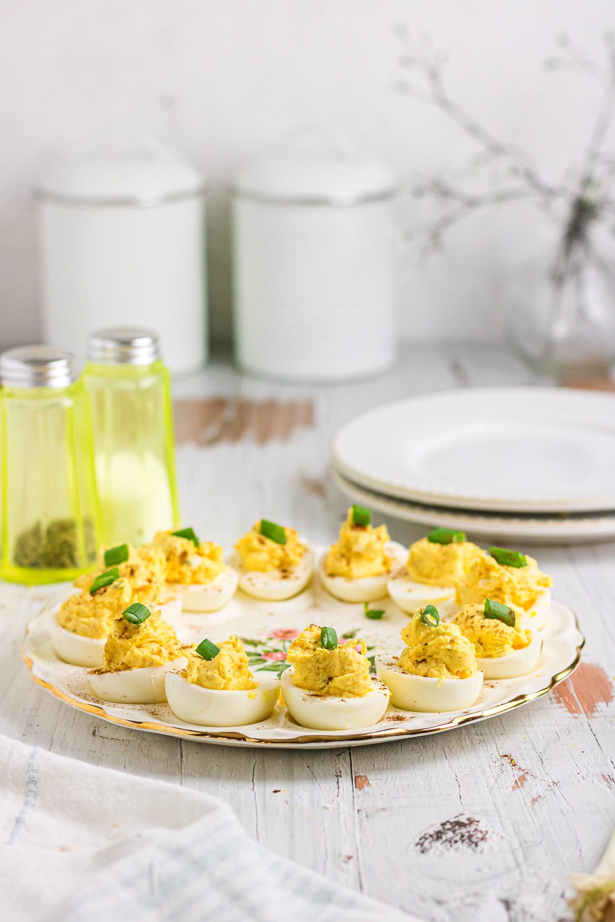 Ranch deviled eggs topped with green onions on an egg platter.