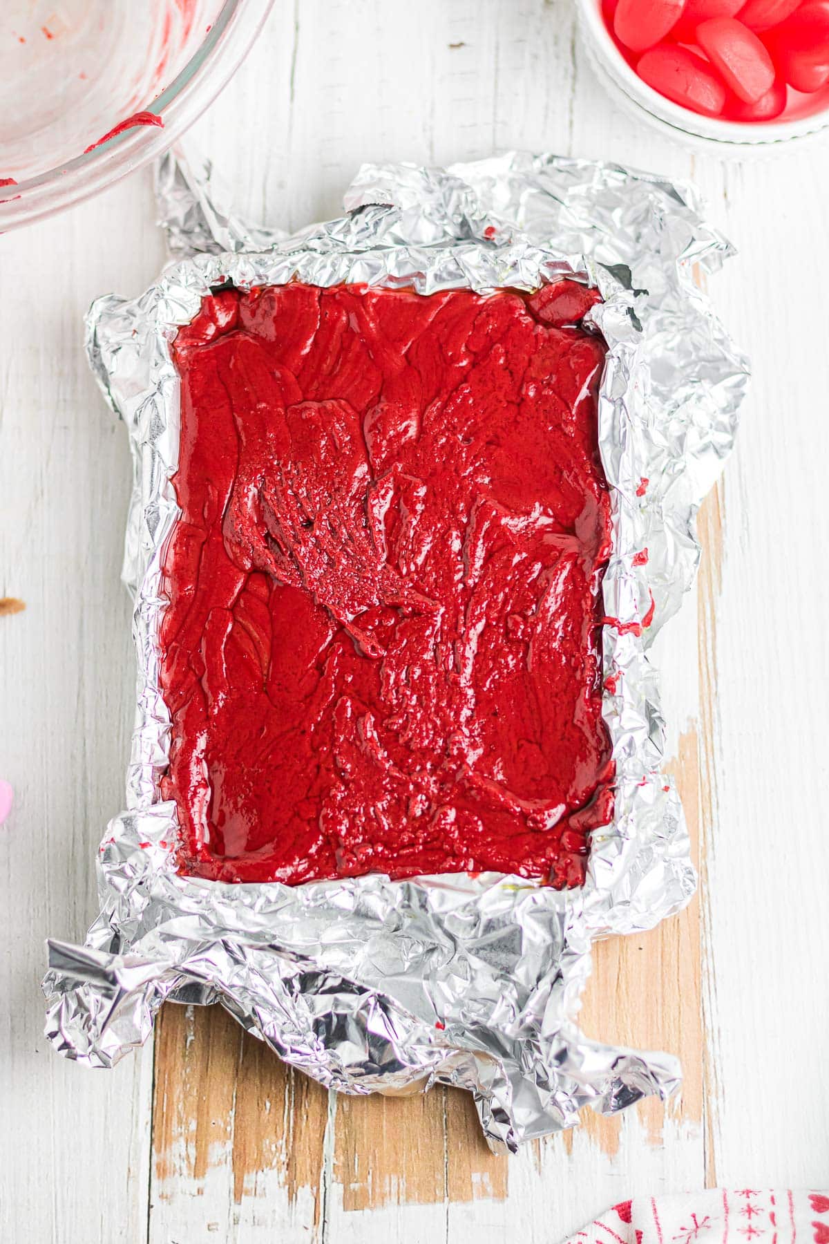 Red velvet fudge batter in a lined pan.
