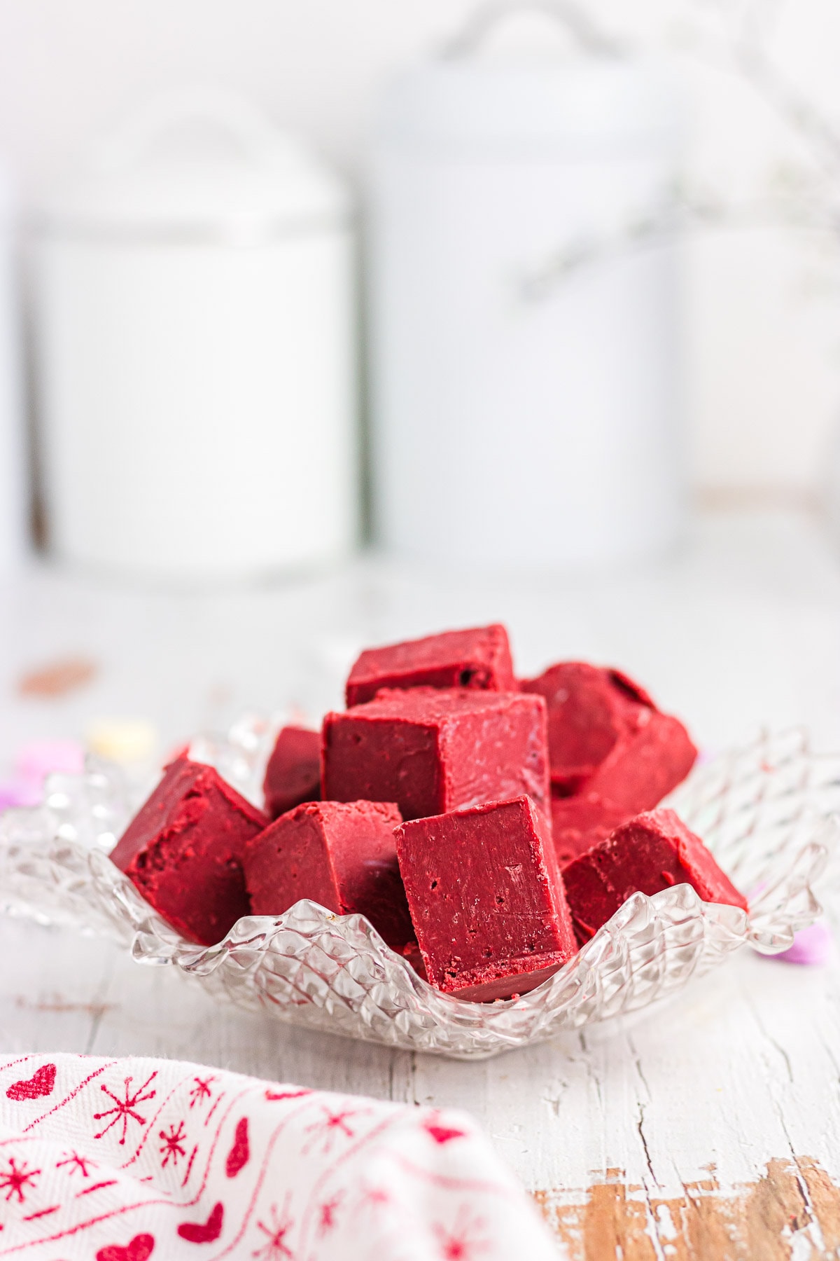 Pieces of red velvet fudge in a decorative glass bowl.