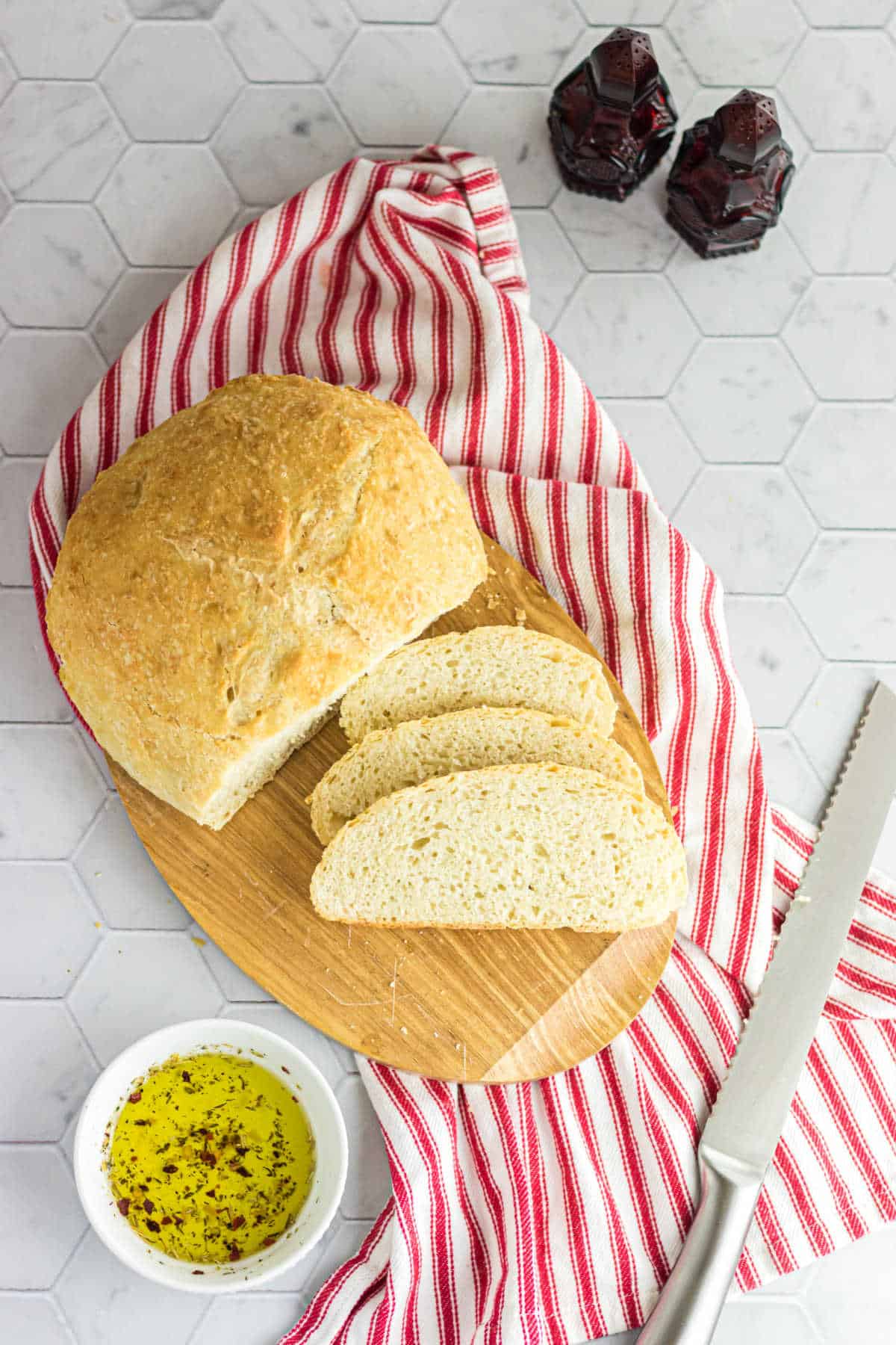 Overheqd view of a loaf of bread sliced on a cutting board.