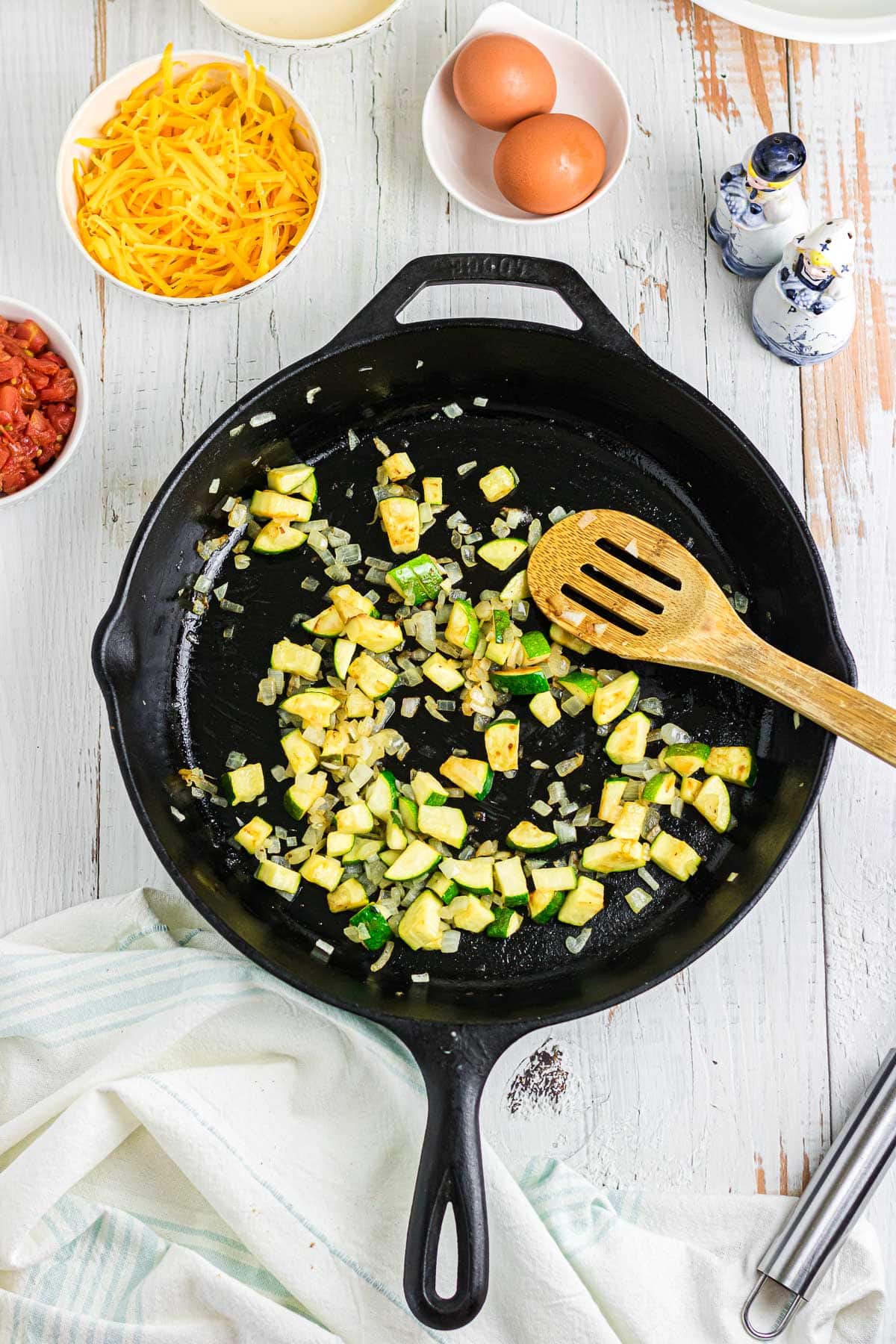 zucchini being cooked in a skillet.