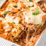 Closeup of a serving of cheesy ricotta chicken casserole being lifted from the dish.