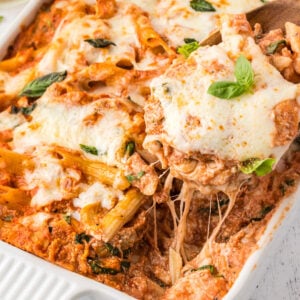 Closeup of a serving of cheesy ricotta chicken casserole being lifted from the dish.