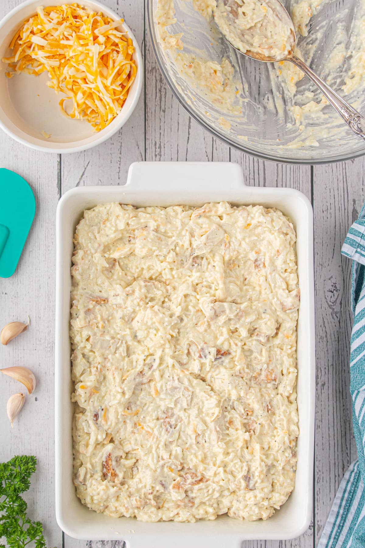 The chicken, rice, and cheese mixture spread in a casserole dish.