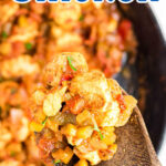 Closeup of a spoonful of chicken creole with a title text overlay for Pinterest.