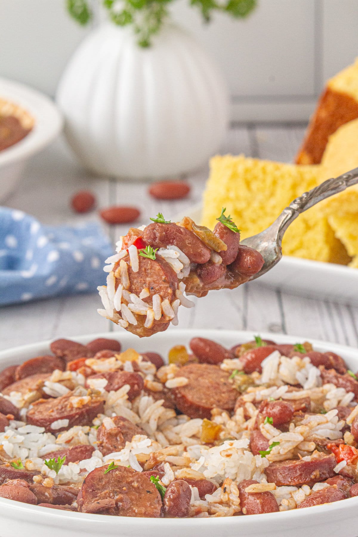 A scoop of Southern red beans and rice on a fork hovered over a full plate.