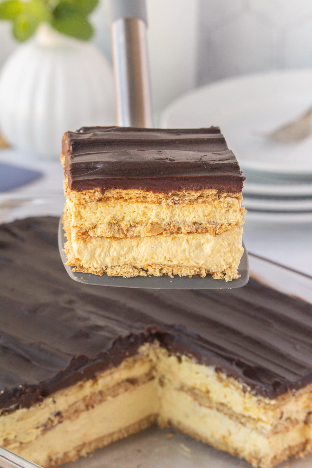 A slice of eclair cake being lifted out of the pan.