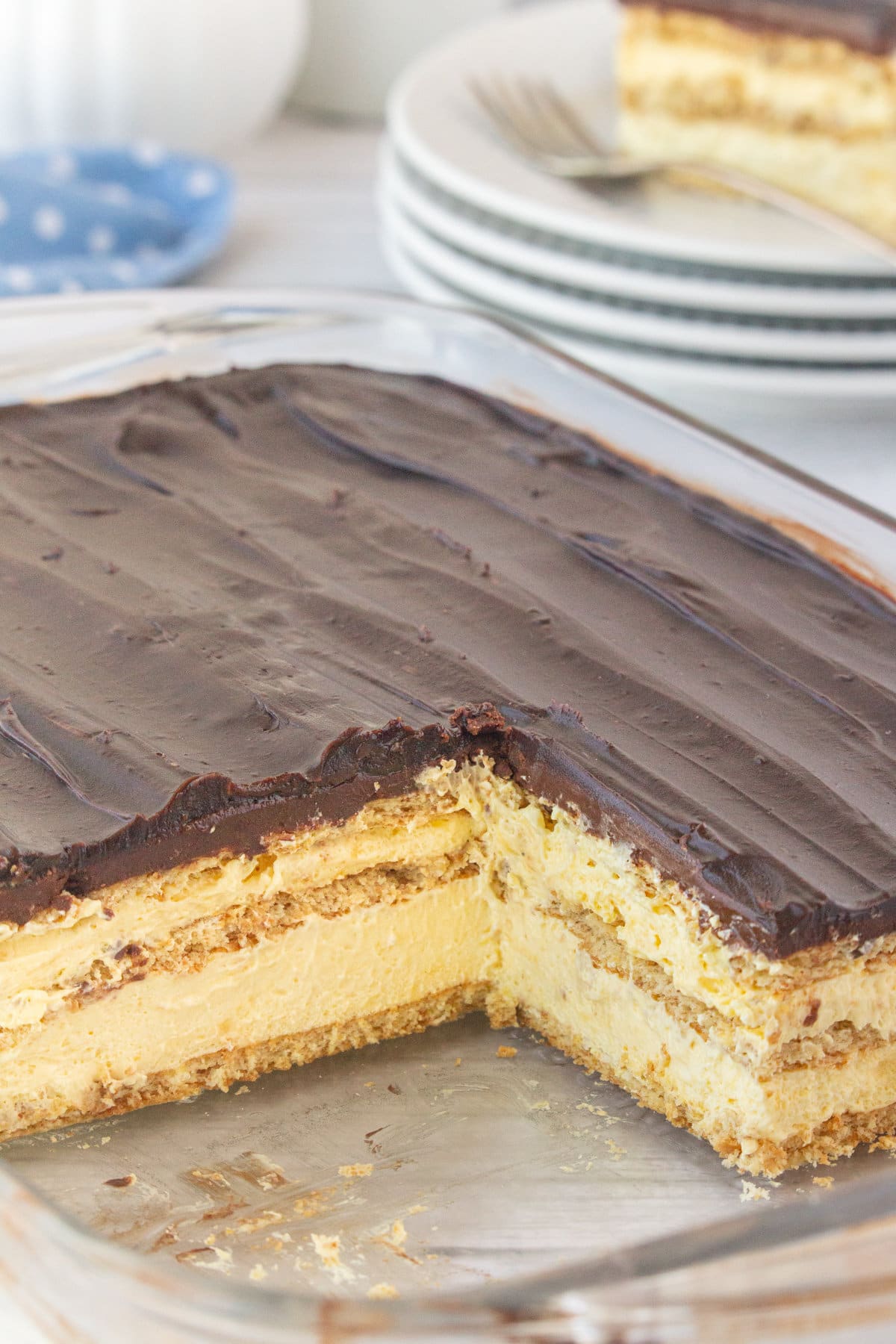 Eclair cake with a slice taken out showing the layers of pudding and graham crackers.