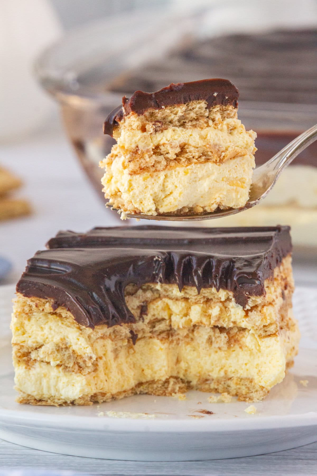 An up-close photo of a slice of eclair cake with a fork scooping a bite.