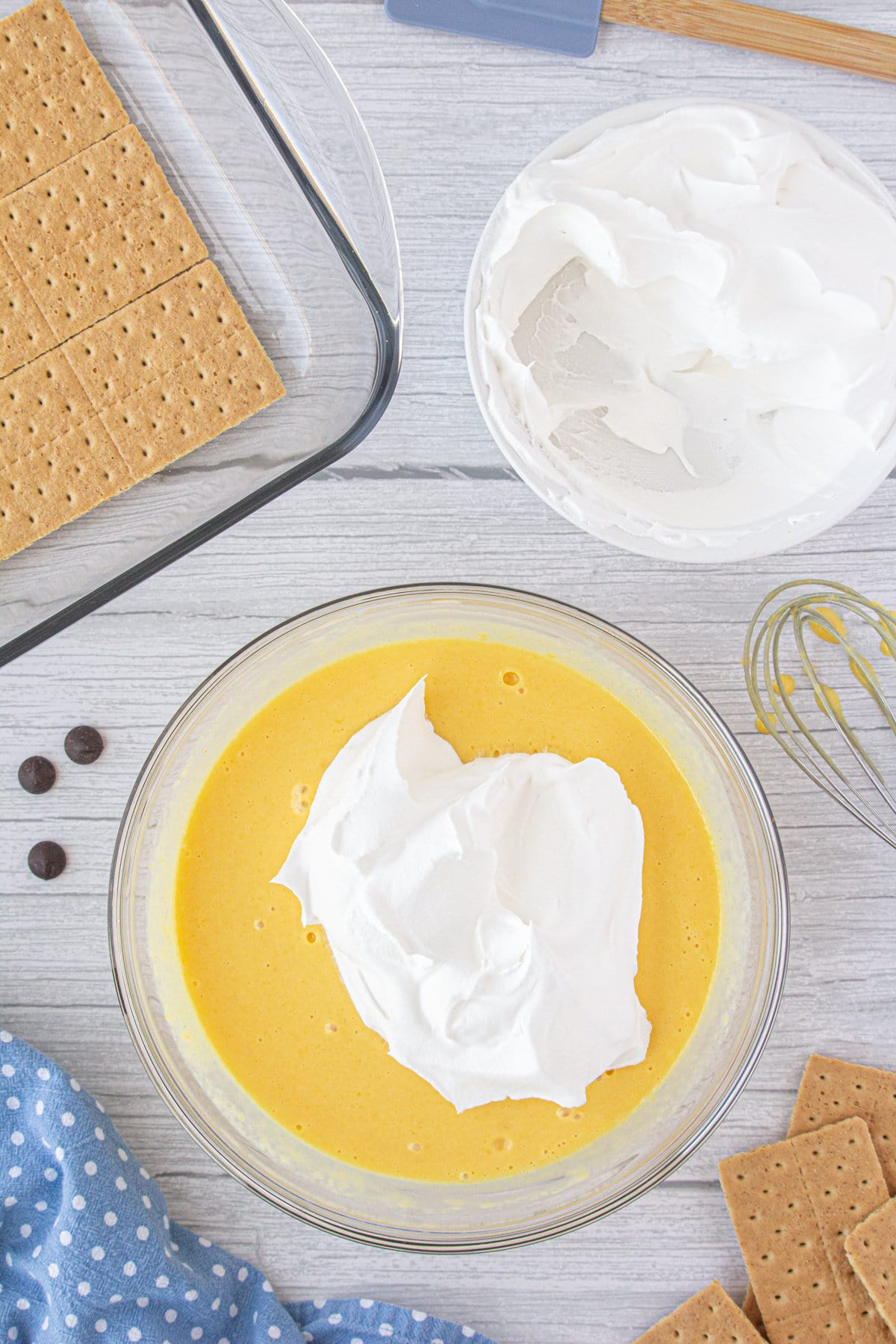 A bowl with vanilla pudding mix, evaporated milk, and Cool Whip.