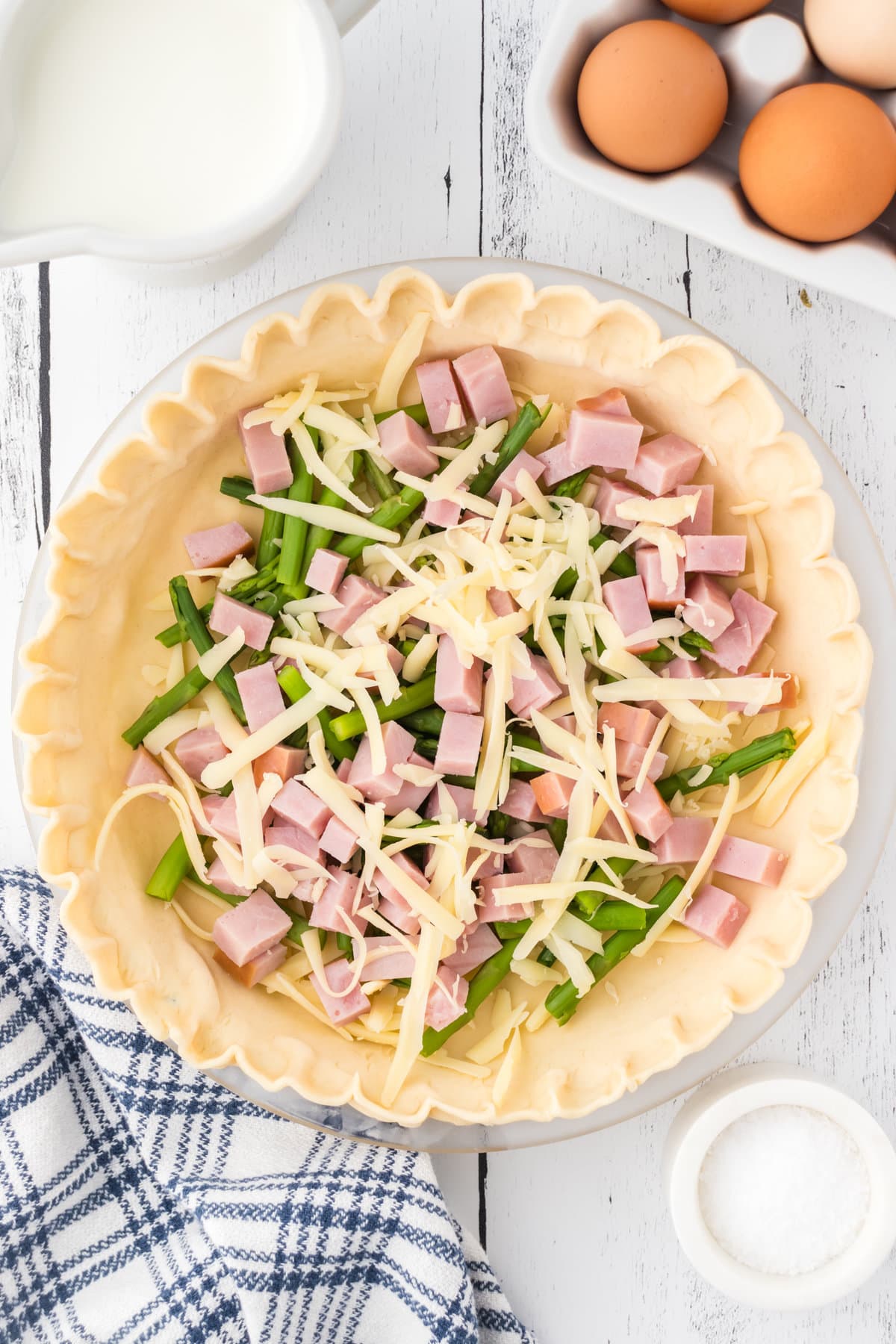 Ham, asparagus, and cheese in an uncooked pie crust.