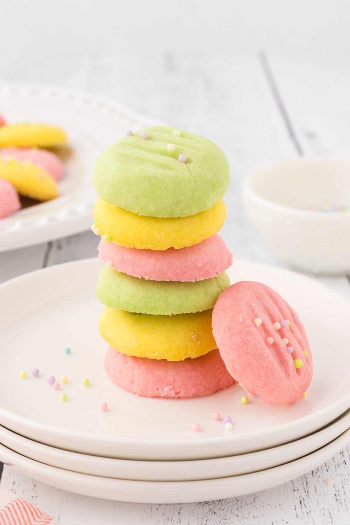 Pink, yellow, and green meltaway cookies stacked on each other on a plate.
