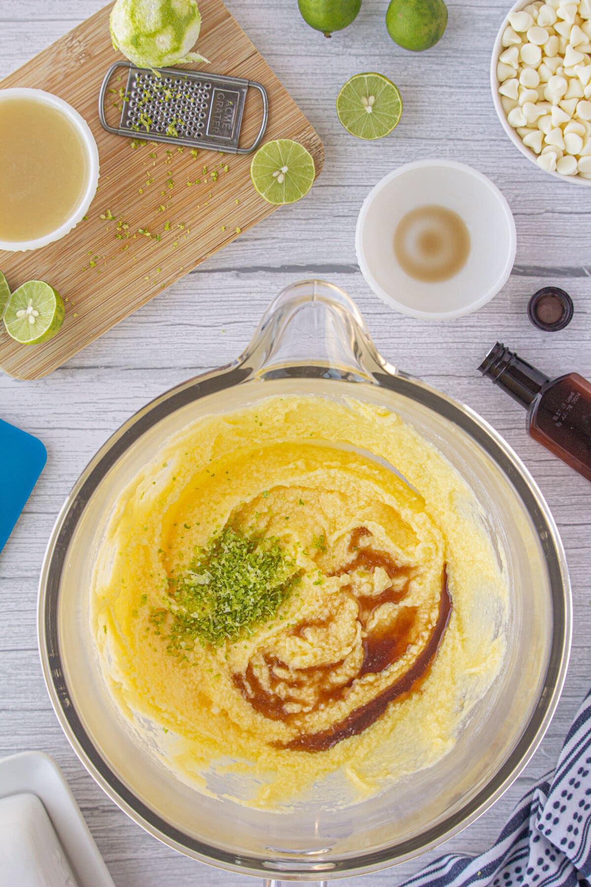 Mixing lime zest and vanilla into the creamed eggs and butter.