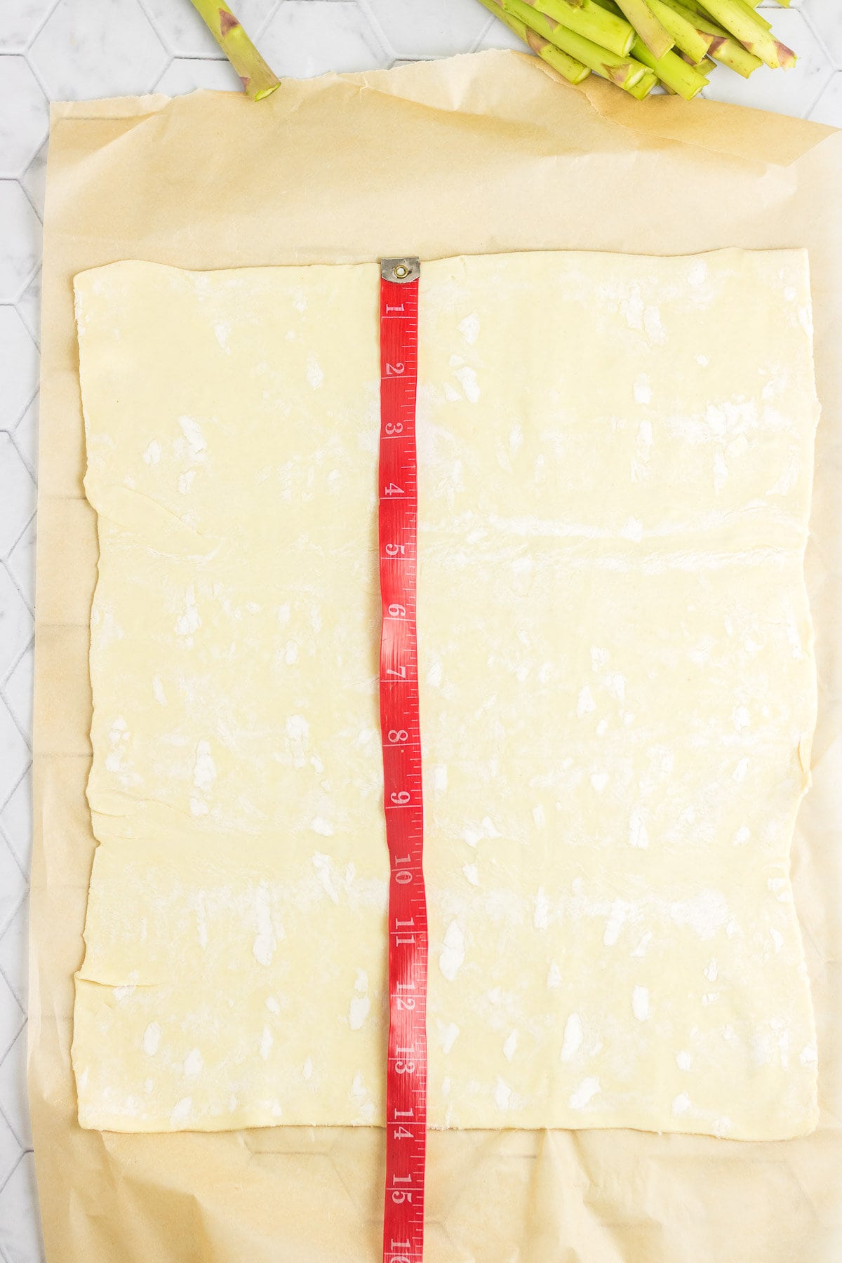 Rolled out puff pastry on parchment paper.