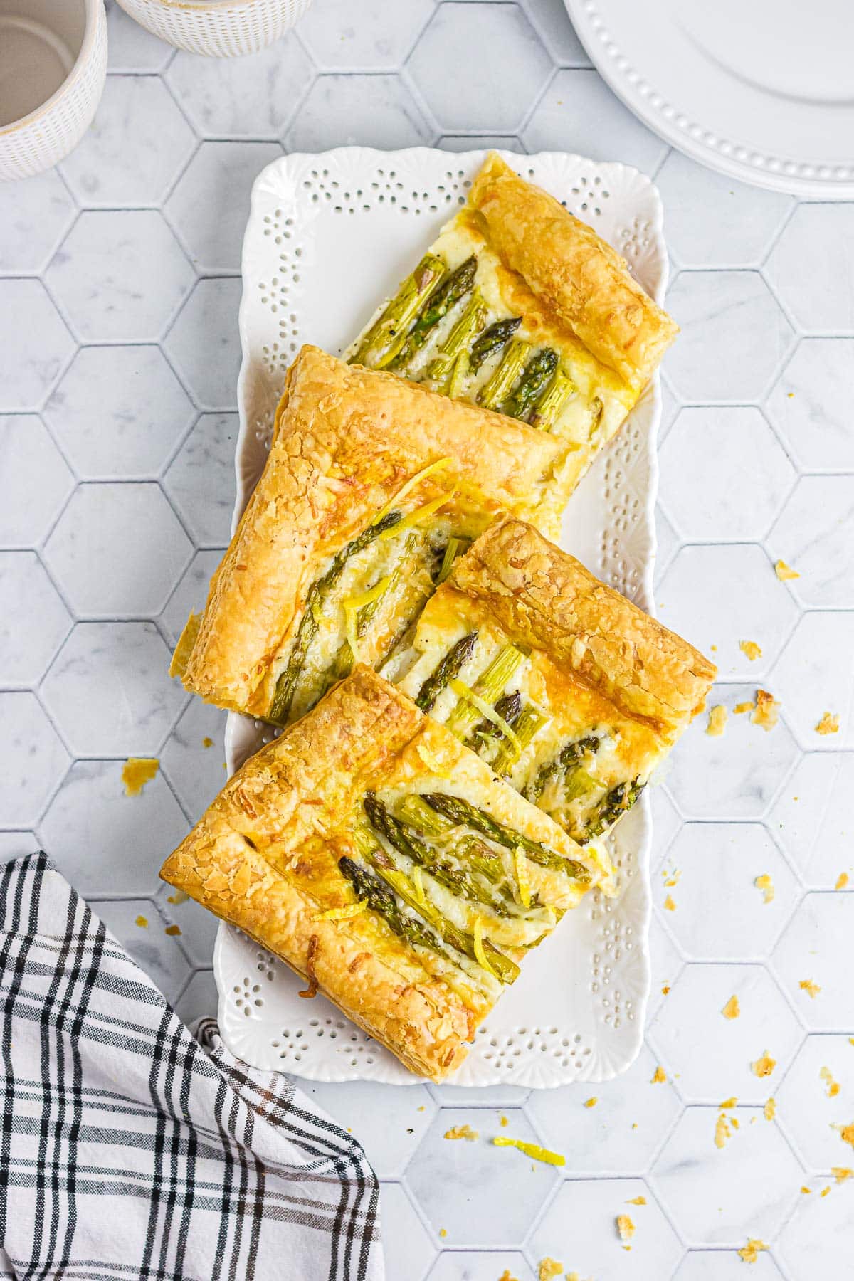 Asparagus tart slices on a decorative white platter.